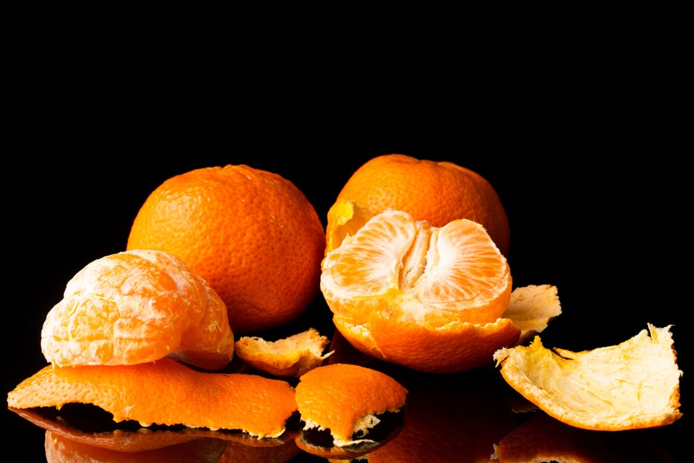 fresh tangerine on a black background with a beautiful reflection close up