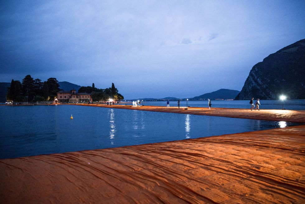 sulzano, italy   june 21 people visit the art installation the floating piers by artist christo vladimirov yavachev, which connects the village of sulzano on the mainland to the islands of monte isola and san paolo via a series of walkways on lake iseo near brescia on june 21, 2016 in sulzano, italy the floating piers, open to the public from june 18 july 3, were made of around 200,000 polyethene cubes covered with 70,000 m2 750,000 sq ft of bright yellow fabric 3 km 19 mi of piers moved on the water another 15 km 093 mi of golden fabric continued along the pedestrian streets in sulzano and peschiera maraglio  photo by max cavallarigetty images