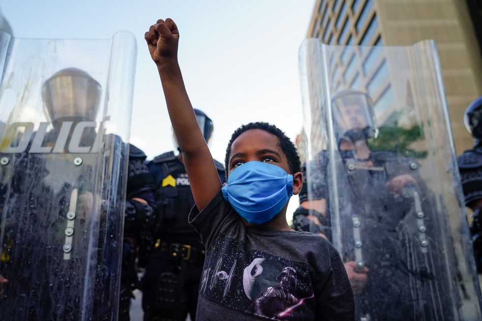 atlanta, ga   may 31 a young boy raises his fist for a photo by a family friend during a demonstration on may 31, 2020 in atlanta, georgia across the country, protests have erupted following the recent death of george floyd while in police custody in minneapolis, minnesota photo by elijah nouvelagegetty images
