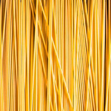 heap of uncooked whole wheat spaghetti italian pasta, top view pasta pattern food background