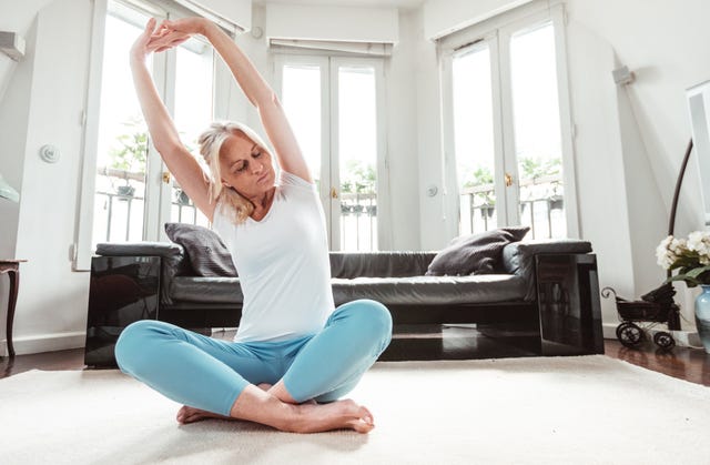 mature adult woman doing yoga at home during the outbreak