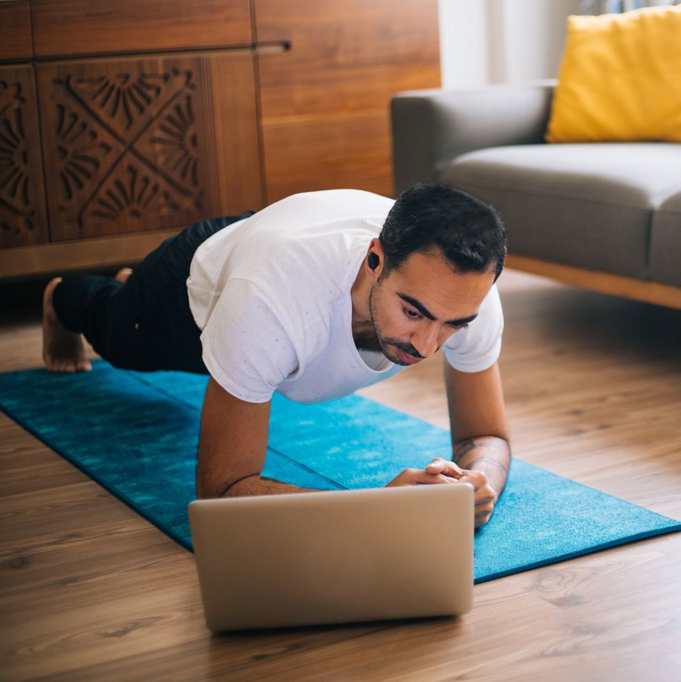 man uses laptop to lean plank position