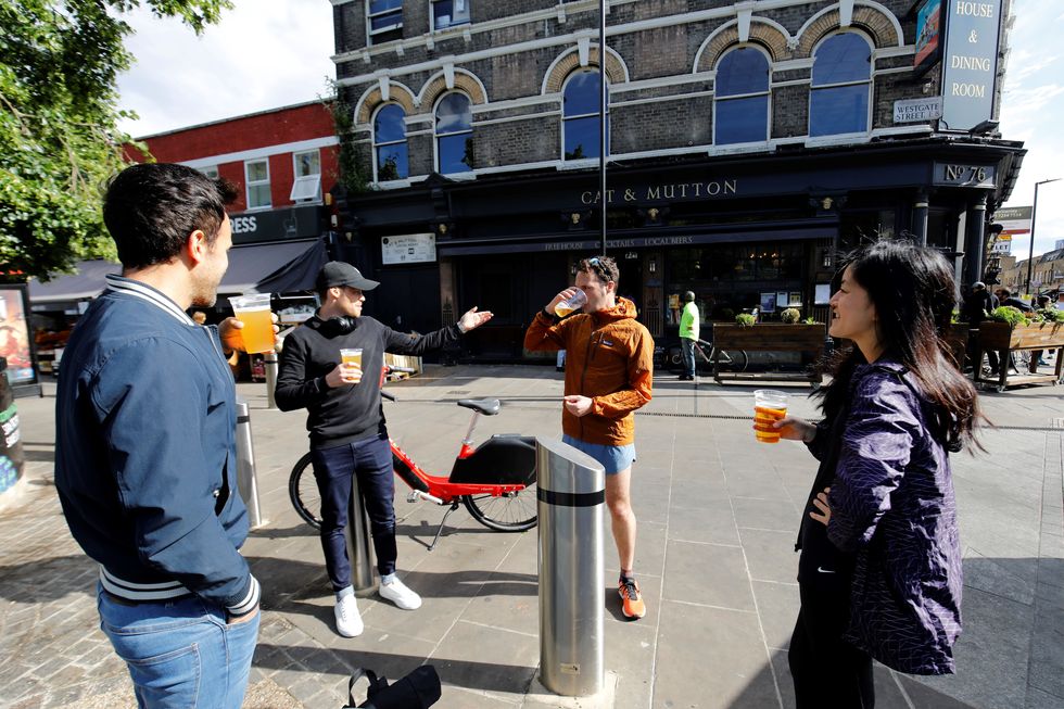customers chat as they drink their takeaway draught beer in plastic cups outside a pub in broadway market, london on june  5, 2020, as lockdown measures are eased during the novel coronavirus covid 19 pandemic photo by tolga akmen  afp photo by tolga akmenafp via getty images