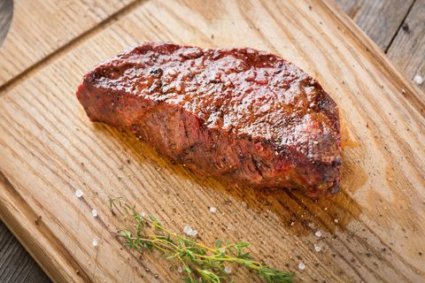 hot grilled whole denver steak on wooden board with herbs fresh juicy medium rare beef grillsteak barbecue meat close up bison