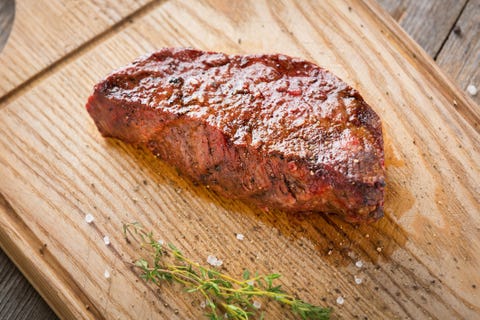 hot grilled whole denver steak on wooden board with herbs fresh juicy medium rare beef grillsteak barbecue meat close up bison