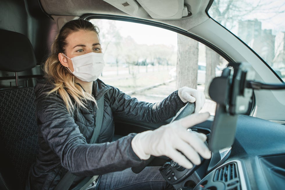 delivering food ordered online while in home isolation during quarantine stay home we deliver sign on box delivery worker checking address on navigation