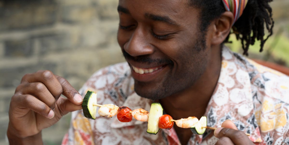 man really diving into a shrimp kebab with zucchini, which is so keto friendly he doesn't even know it