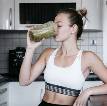 beautiful young and fit woman having a blended fruit for breakfast