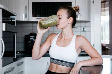 beautiful young and fit woman having a blended fruit for breakfast