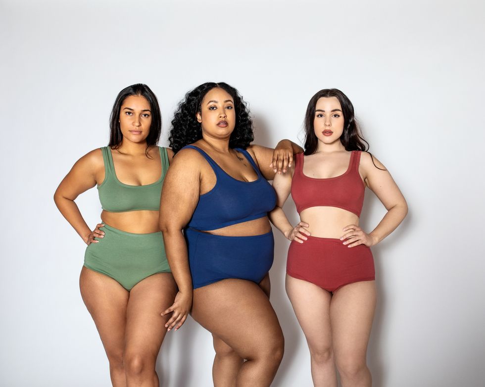 group of women with different body shapes standing together in their underwear on white background