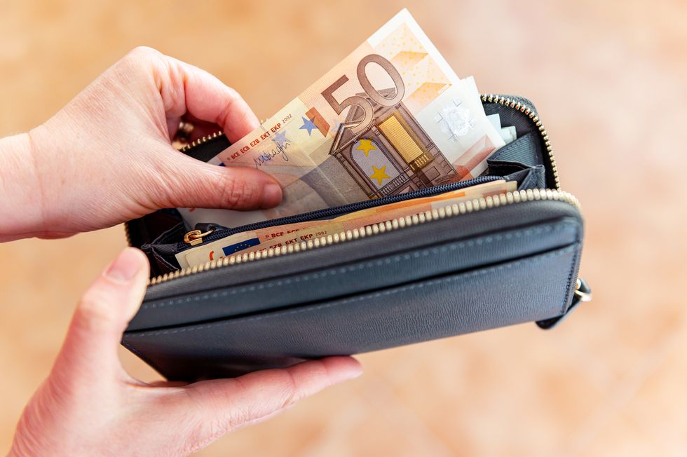 closeup image of human hands taking out 50 euro bill from a wallet coronavirus crisis
