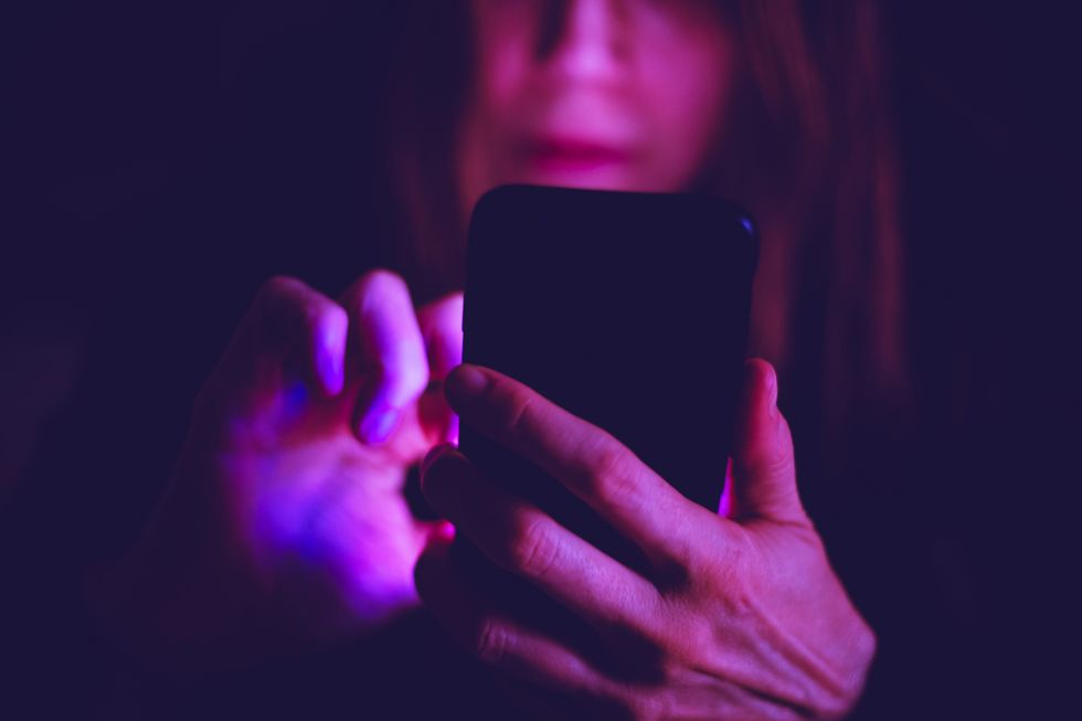 a woman text messagingusing cell phones at late hours may cause sleep deprivation and exhaustion smart phone habits are affecting sleep and brain's health