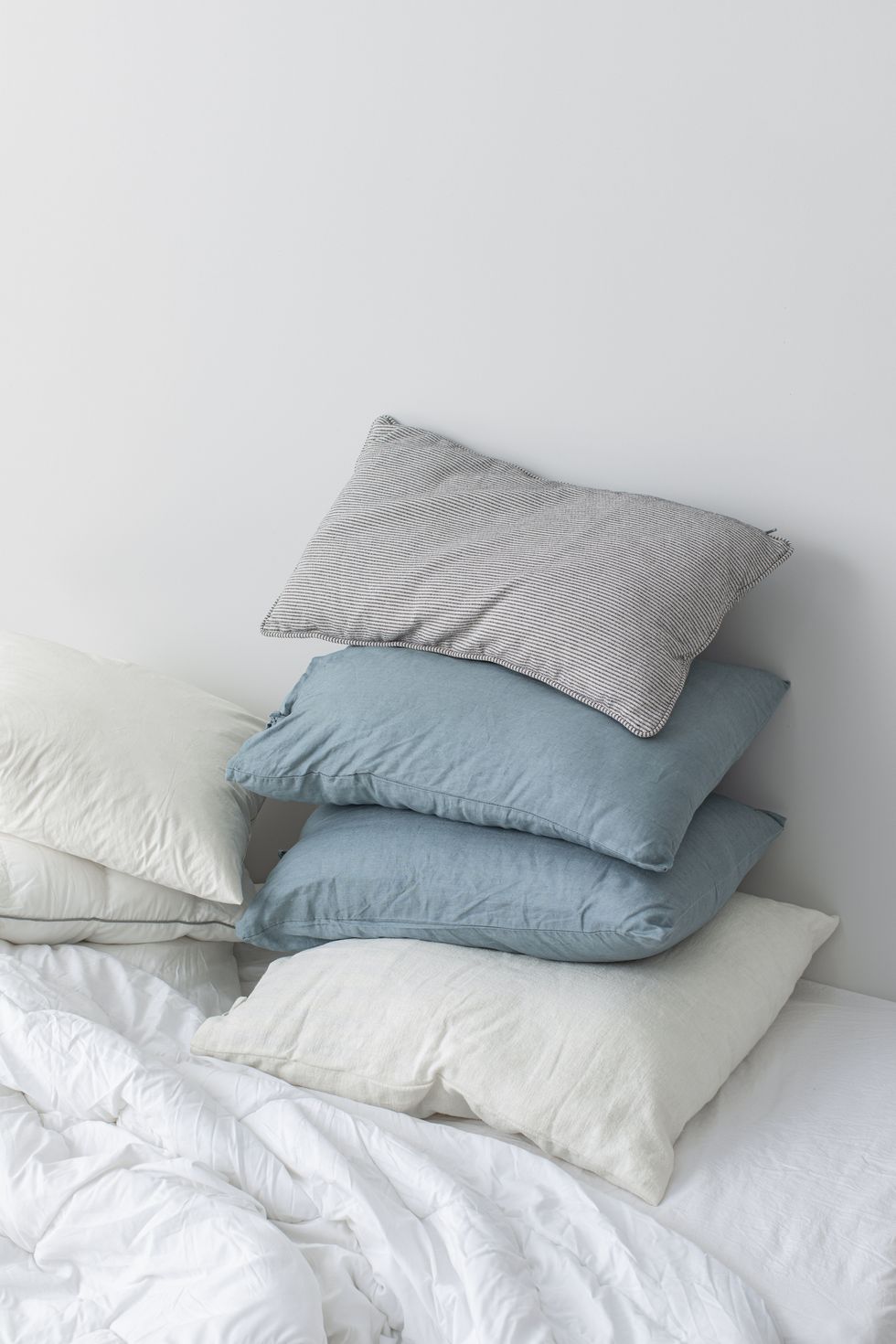 pile of soft pillows on a bed