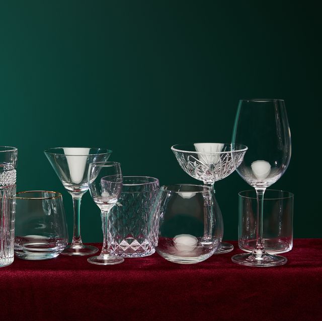 set of glasses old fashioned glass, cocktail glass, champagne glass, highball glass, liqueur glass, brandy glass, cognac balloon and collins glass on green background