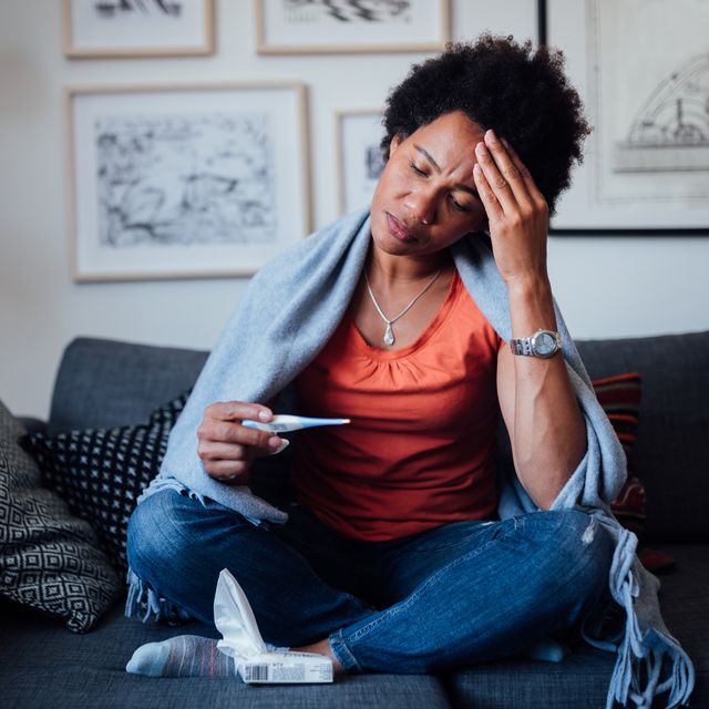 worried african american woman sitting at home while being sick