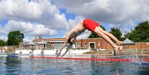 a swimmer dives into the water at parliament hill lido in london on july 11, 2020, as restrictions are further eased during the novel coronavirus covid 19 pandemic   first opened in 1938 parliament hill lido in north london is an unheated open air swimming pool, open to members of the public 365 days a year photo by justin tallis  afp photo by justin tallisafp via getty images