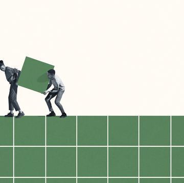 full length of young woman and man carrying large green block on grid against white background