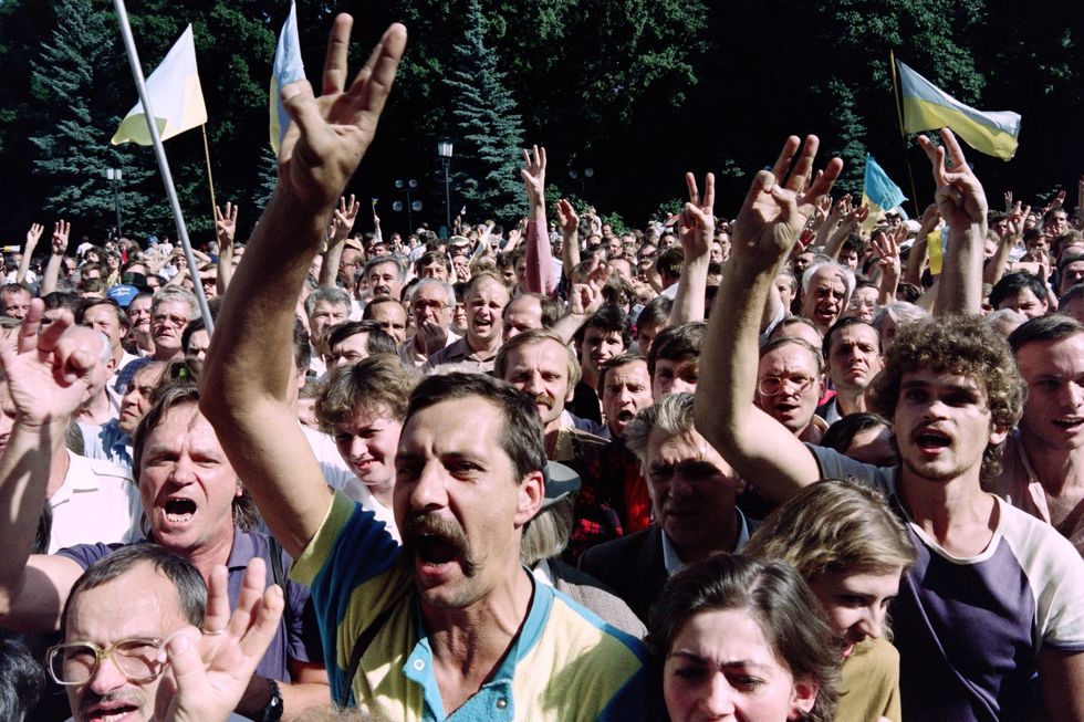 Duizenden demonstranten voor de onafhankelijkheid van Oekrane steken op 28 augustus 1991 in het centrum van Kiev drie vingers op als teken van de drietand die het symbool van het land is