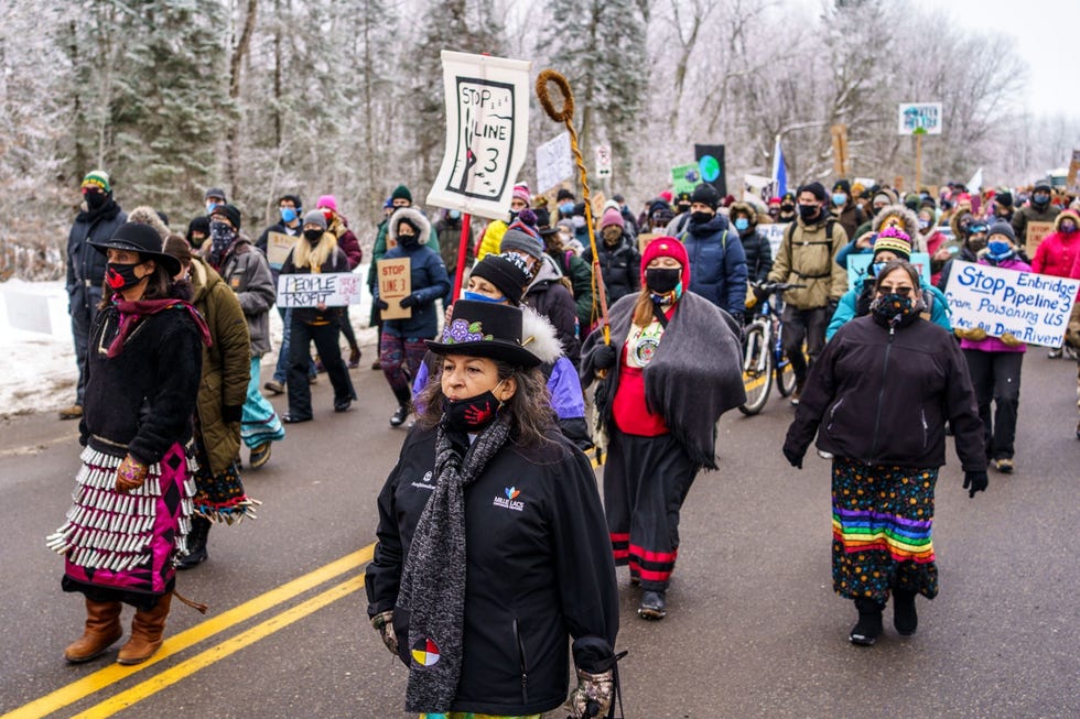 Milieuactivisten en inheemse Amerikanen lopen op 9 januari 2021 in een protestmars naar een bouwplaats voor de aanleg van de Line 3oliepijpleiding bij Palisade Minnesota Line 3 roept telkens weer verzet op van pleitbezorgers voor klimaatgelijkheid en inheemsAmerikaanse gemeenschappen in Minnesota