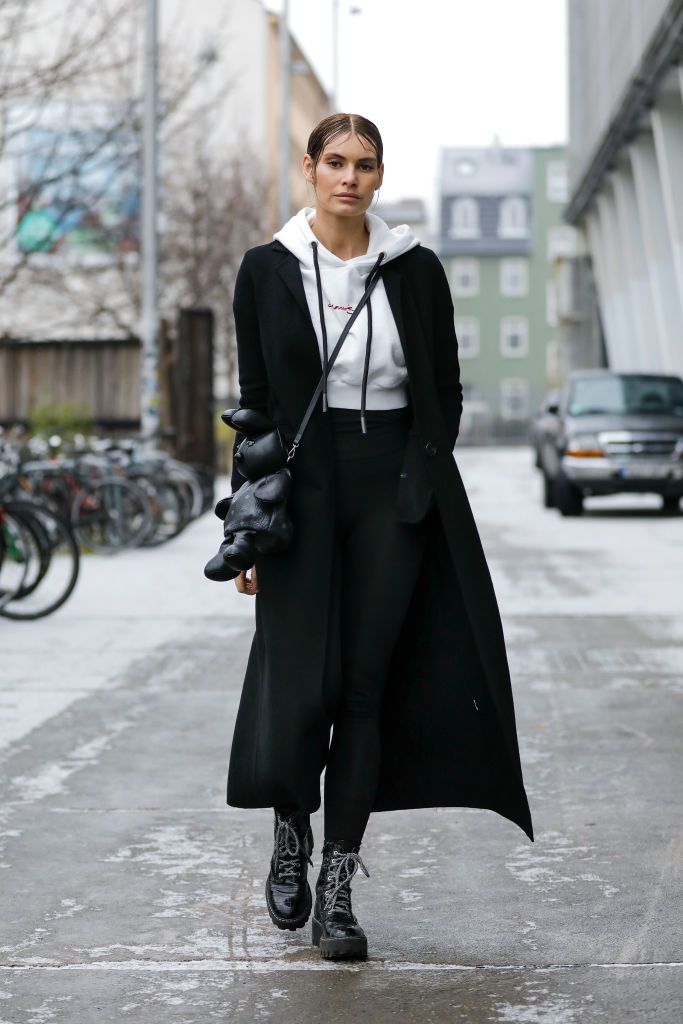 berlin, germany   january 18 actress and model rebecca kunikowski wearing a long black handmade cashmere coat by zara, a white sustainable cropped hoodie by leftright clothing, black boots by zara, black leggings by bcbg max azria and a black bunny bag by mcm during a street style shooting at the mercedes benz fashion week berlin january 2021 on january 18, 2021 in berlin, germany photo by streetstyleshootersgetty images