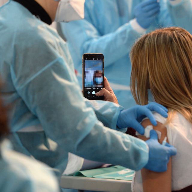 woman takes a selfie while getting the vaccine