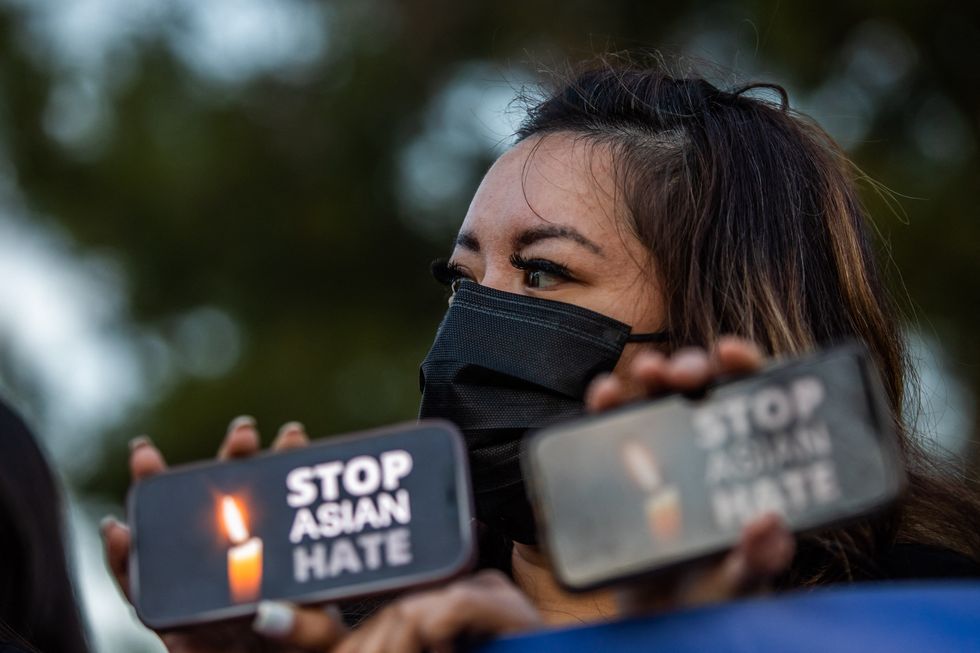 clover tran holds her phone during a candlelight vigil in garden grove, california, on march 17, 2021 to unite against the recent spate of violence targeting asians and to express grief and outrage after yesterdays shooting that left eight people dead in atlanta, georgia, including at least six asian women   police have said suspect robert aaron long, a 21 year old white man, has so far denied a racist motive for the three shootings in the southern us state of georgia photo by apu gomes  afp photo by apu gomesafp via getty images