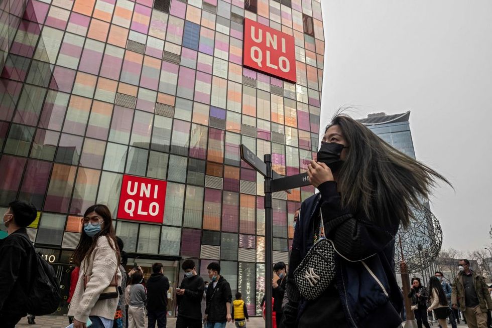 people walk past a uniqlo store in beijing on april 5, 2021 photo by nicolas asfouri  afp photo by nicolas asfouriafp via getty images