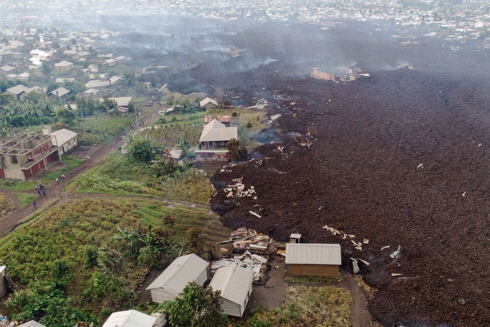 Gebouwen in het dorp Bushara aan de rand van de stad Goma in de Democratische Republiek Congo worden op 23 mei 2021 verzwolgen door deels gestolde lava nadat de vulkaan Nyiragongo tot uitbarsting is gekomen