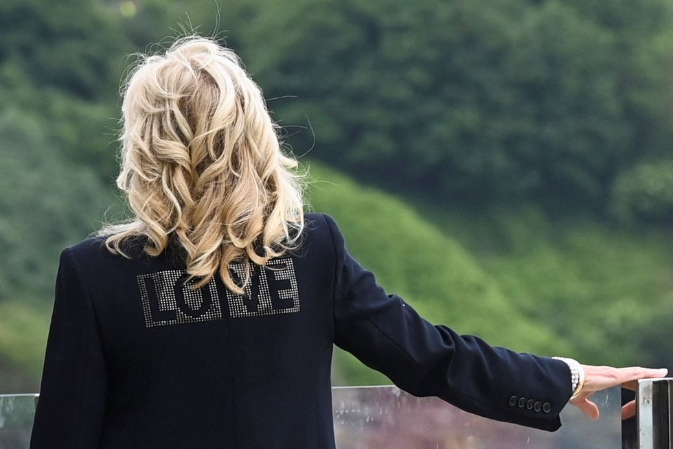 us first lady jill biden, wearing a jacket with the words love on the back, looks out over the sea as she stands with us president joe biden and britains prime minister boris johnson and his wife carrie johnson all unseen prior to a bi lateral meeting at carbis bay, cornwall on june 10, 2021, ahead of the three day g7 summit being held from 11 13 june   g7 leaders from canada, france, germany, italy, japan, the uk and the united states meet this weekend for the first time in nearly two years, for the three day talks in carbis bay, cornwall   photo by toby melville  afp photo by toby melvilleafp via getty images