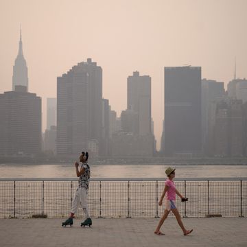 a man skates as a woman walks before the manhattan city skyline at a park in the brooklyn borough of new york on july 20, 2021   domestic media reported that smoke from wilfires buring on the west coast had made its way across the country as world air quality project published an air quality index reading of 172, or unhealthy for new york city photo by ed jones  afp photo by ed jonesafp via getty images
