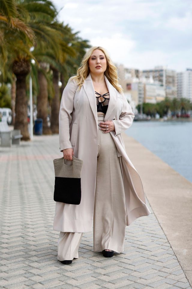palma de mallorca, spain august 14 in this image released on august 17, us actress and plus size model hayley amber hasselhoff wearing a long beige coat by marina rinaldi, beige high waist and wide leg pants by marina rinaldi, the black brianna bra with mesh, floral lace and strap details by elomi, silver rings by cos and black chunky high heel sandals by asos during a street style shoot on august 14, 2021 in palma de mallorca, spain photo by streetstyleshootersgetty images