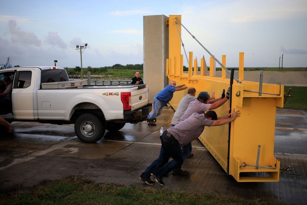 In Golden Meadow Louisiana duwen medewerkers een vloedkering op de snelweg Louisiana Route 1 weer open nadat automobilisten de deadline voor de afsluiting van de weg hebben gemist en geen kant meer op kunnen terwijl hurricane Ida nadert