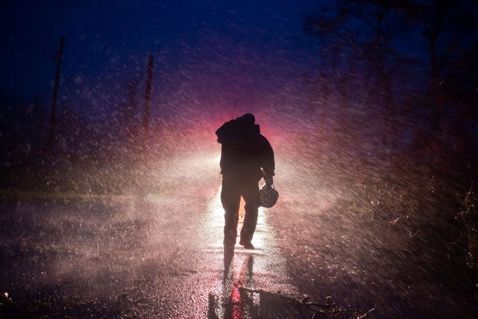 https://i.natgeofe.com/n/7703fc1c-0614-4035-a74d-92a8fc8bddda/GettyImages-1234951663.jpg Commandant Toby Henry van de brandweer van Montegut loopt in de harde regen terug naar zijn wagen terwijl leden van zijn team in Bourg Louisiana een omgevallen boom in stukken zagen De zware storm van categorie 4 trof de kust van Louisiana met windsnelheden van 240 kilometer per uur en zwakte later af tot een tropische storm die volgens het National Hurricane Center nog altijd extreem gevaarlijk was