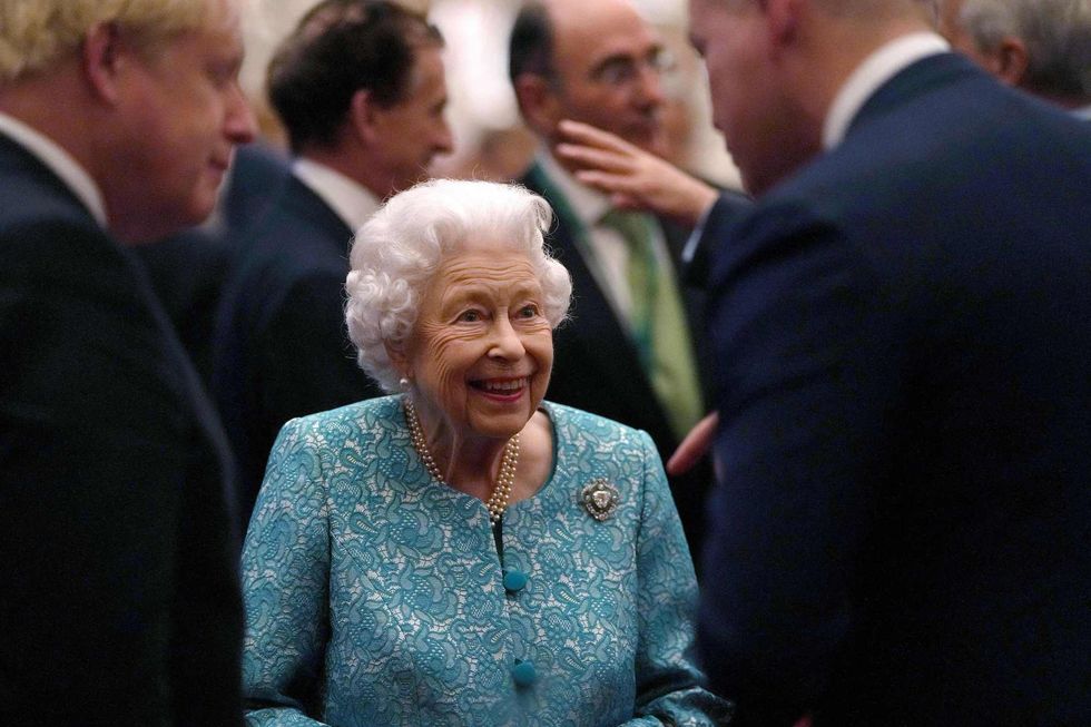 britain's queen elizabeth ii c and britain's prime minister boris johnson l greet guests during a reception to mark the global investment summit, at windsor castle in windsor, west of london on october 19, 2021 photo by alastair grant  pool  afp photo by alastair grantpoolafp via getty images