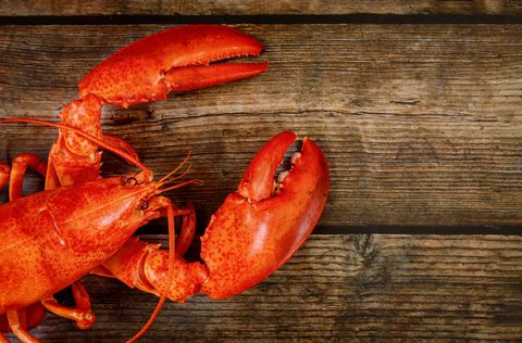 wooden background with cooked red large lobster top view