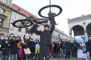 29 november 2021, bavaria, munich german extreme athlete jonas deichmann lifts his bike into the air at odeonsplatz at the finish of his triathlon around the world he cycled the last leg from portugal to munich he started in munich on 26 september 2020, where he has now completed his journey photo felix hörhagerdpa photo by felix hörhagerpicture alliance via getty images