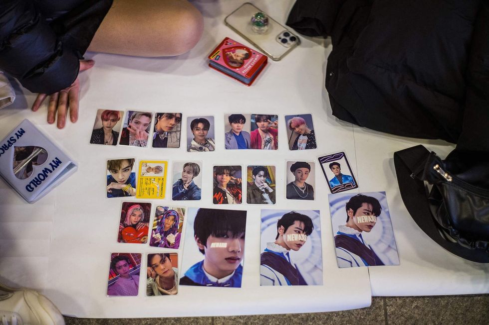 fans of south korean k pop boy band nct gather at the entrance of a metro station to swap collectable cards featuring images of band members after buying their third album 'universe' from a nearby store in seoul on december 15, 2021, a day after its release photo by anthony wallace  afp photo by anthony wallaceafp via getty images