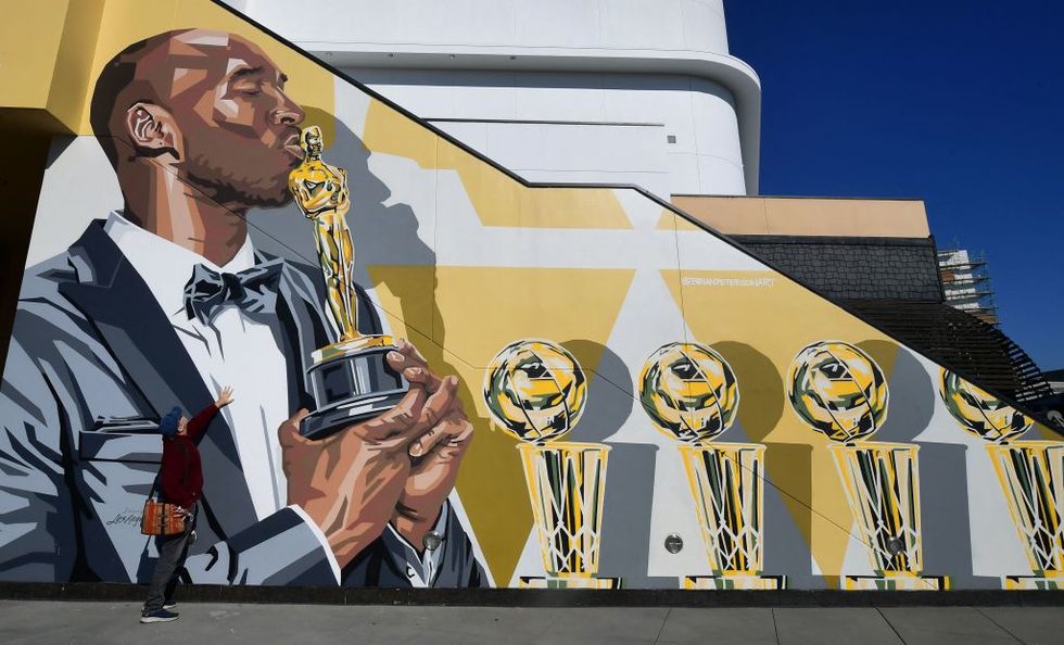 a man touches a mural by artist bryan peterson of the late kobe bryant depicted kissing his academy award on january 25, 2022 in hollywood, california, a day before the two year death anniversary of the former los angeles lakers star   lakers star kobe bryant died with his daughter gianna in a tragic helicopter crash which killed nine people on january 27, 2020   restricted to editorial use   mandatory mention of the artist upon publication   to illustrate the event as specified in the caption photo by frederic j brown  afp  restricted to editorial use   mandatory mention of the artist upon publication   to illustrate the event as specified in the caption  restricted to editorial use   mandatory mention of the artist upon publication   to illustrate the event as specified in the caption photo by frederic j brownafp via getty images