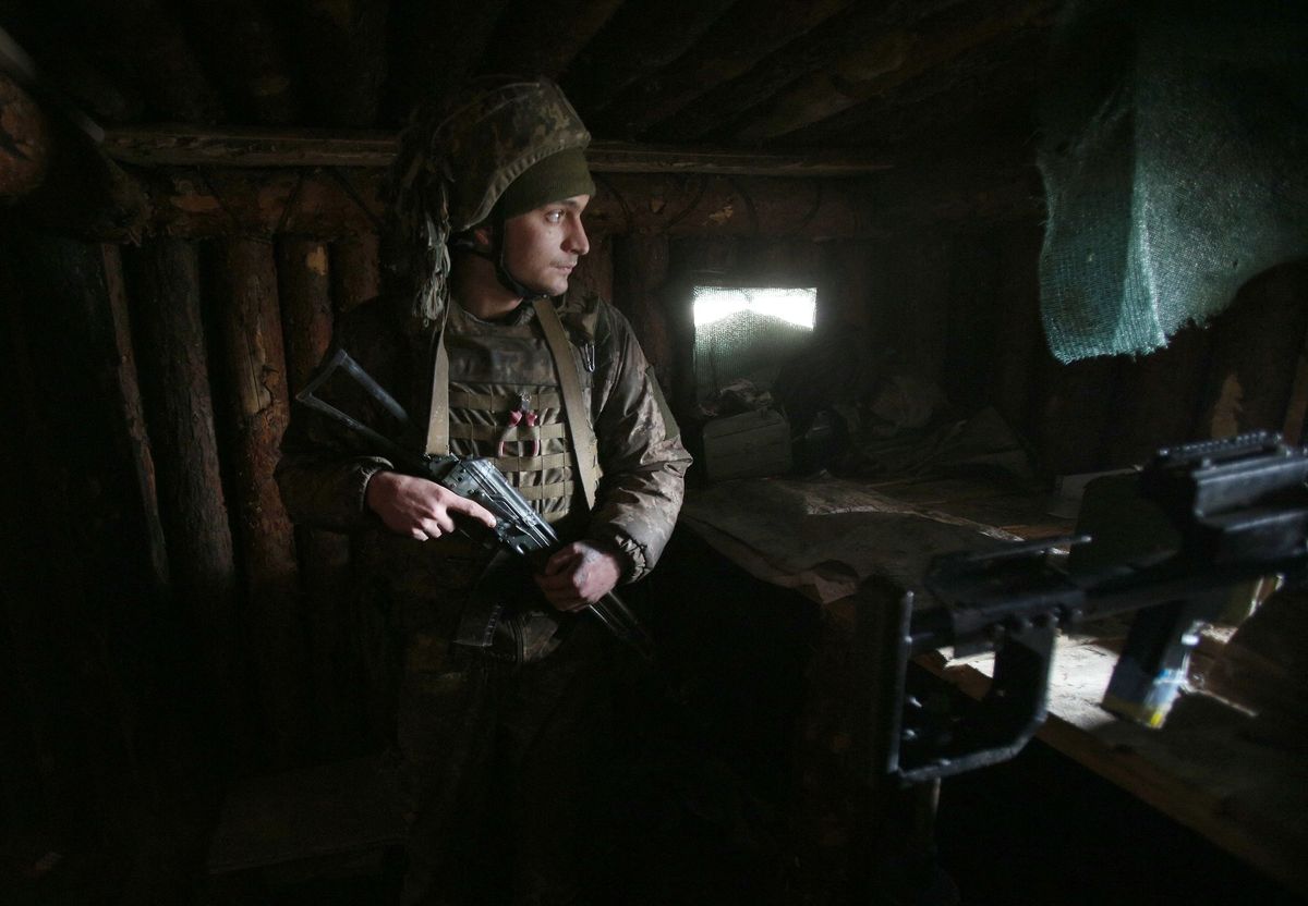 Een Oekraense soldaat houdt op 23 februari 2022 een dag voor de Russische invasie in Oekrane de wacht in de plaats Schastia wat in zowel het Russisch als het Oekraens blijdschap betekent langs het front met de door Rusland gesteunde separatisten in de buurt van de Oekranse stad Loehansk