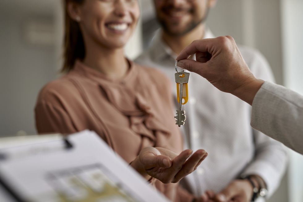 close up of real estate agent giving new house keys to a couple