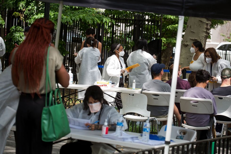 Zorgmedewerkers helpen op 14 juli 2022 mensen die wachten op een injectie met het apenpokkenvaccin op een vaccinatielocatie in New York