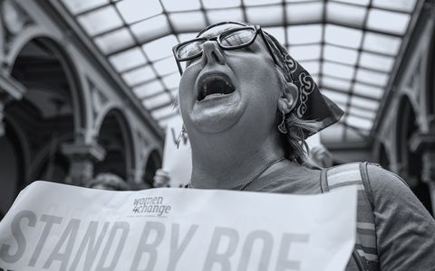 an abortion rights protester shouts while holding a sign in the indiana state capitol building
