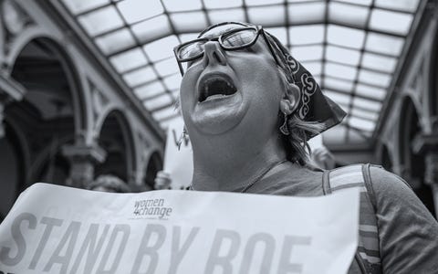 Indiana State Legislature Holds Special Session To Consider New Abortion Laws an abortion rights protester shouts while holding a sign in the indiana state capitol building