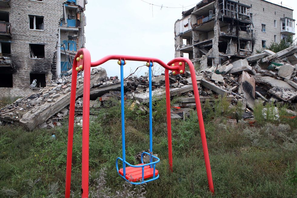 a swing is pictured in front of an apartment building destroyed as a result of russian shelling in izium
