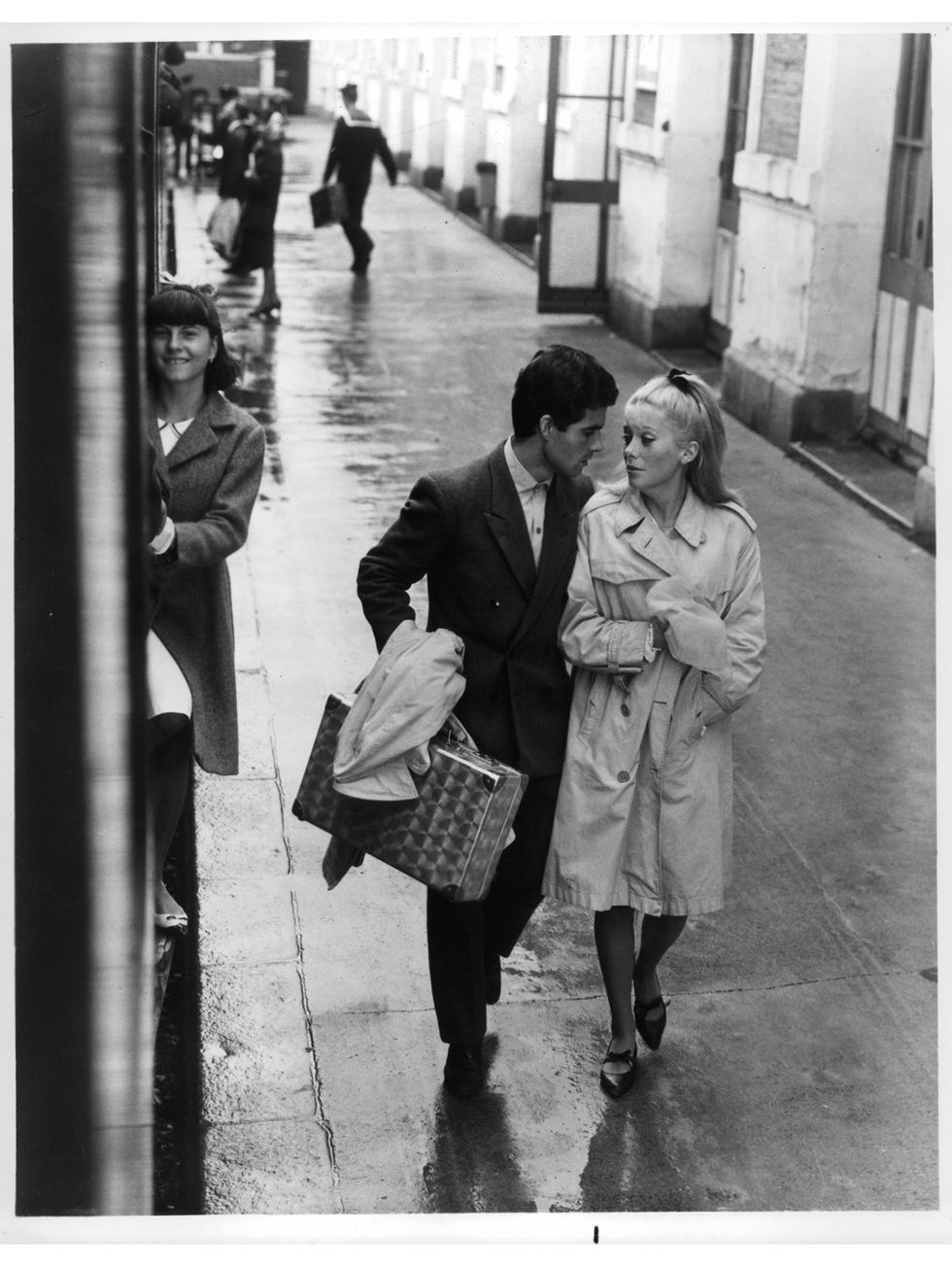nino castelnuovo and catherine deneuve walk down a wet sidewalk in a scene from the film 'the umbrellas of cherbourg', 1964 photo by landau releasing organizationgetty images