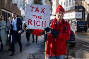 phil white, a british millionaire poses with a placard reading tax the rich next to the congress centre during the world economic forum wef annual meeting in davos on january 18, 2023 tax me and tax people like me urges in an interview with afp phil white, a british millionaire present at the davos forum, believing that wealth inequalities fragment the world photo by fabrice coffrini afp photo by fabrice coffriniafp via getty images