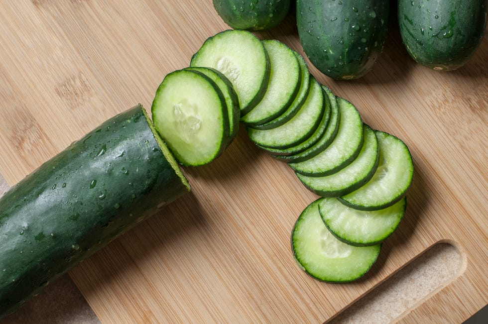 fresh cucumber slices on a wooden cutting board