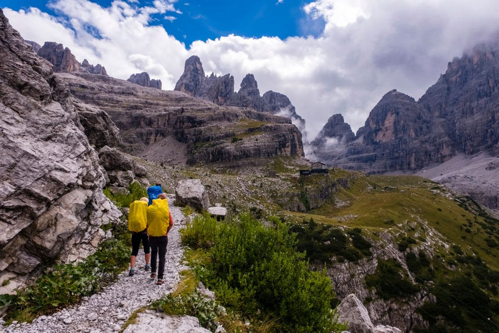 madonna di campiglio, trentino alto adige, italy 20220908 three hikers walking on a path leading to the mountain hut rifugio maria e alberto al brentei in val brenta in brenta dolomites photo by frank bienewaldlightrocket via getty images
