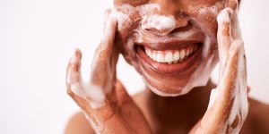 studio shot of an unrecognizable woman washing her face against a white background