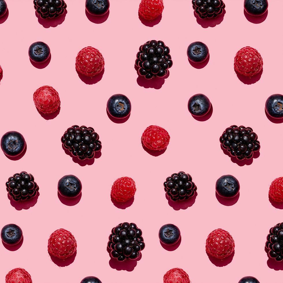 pattern of raspberries, blueberries and blackberries against pink background